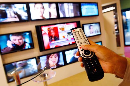 A visitor uses a remote control as she looks at television programmes during the annual MIPCOM television programme market in Cannes, southeastern France, October 4, 2010.